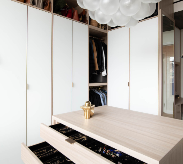 Two-toned Walk-in Closet full room walk-in closet with open and closed cabinetry white & natural wood combo with island in center and dedicated jewelry drawer storage Upper East Side New York City