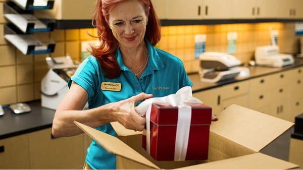 The UPS Store employee packing a Holiday gift