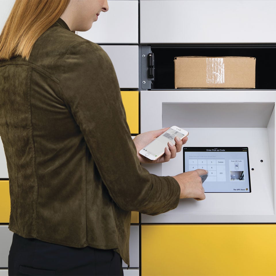 Woman retrieving package from locker
