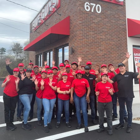 Employees pose for a photograph outside the restaurant ahead of the grand opening of the Five Guys at 670 Broadway in Saugus, Massachusetts.
