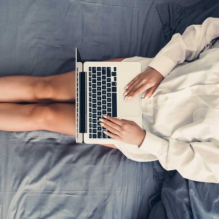 Someone using their laptop in bed