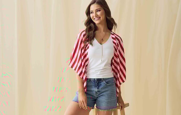 Woman is wearing a white tank top, jean shorts and a red and white stripe kimono.