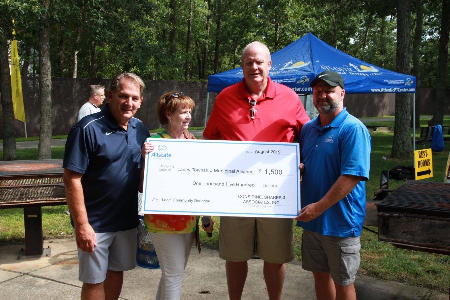 Bob Considine presents $1500 sponsorship to Lacey Municipal Alliance representatives.