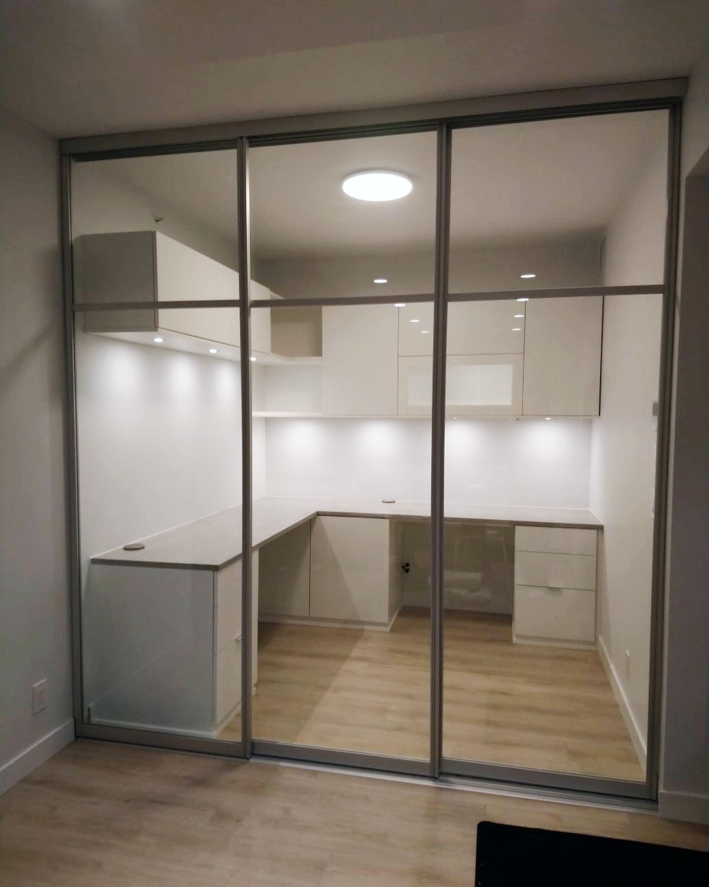 Custom office and sliding doors Custom built office tucked behind a three panel glass sliding door