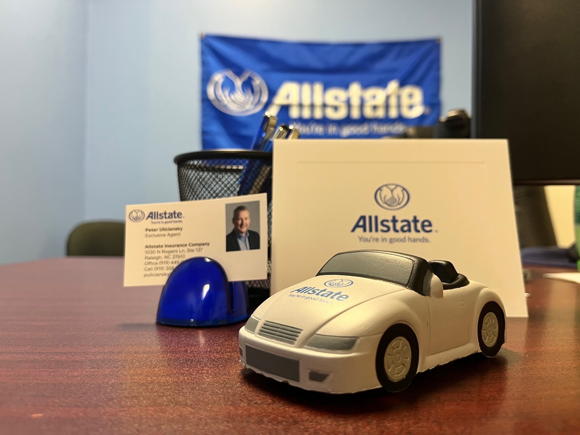 Desk in office with plush toy car and business card