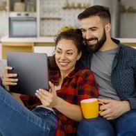 a couple relaxes on the couch and uses PFM