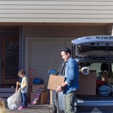 Dad and son carry boxes into their new home.
