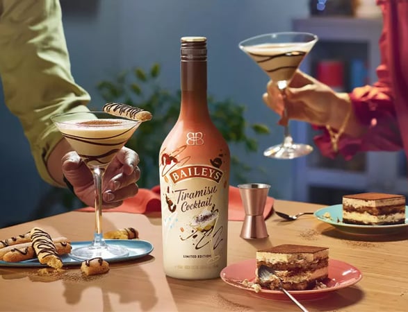 Two people holding glasses with cocktails made with the Baileys Tiramisu Cocktail flavour