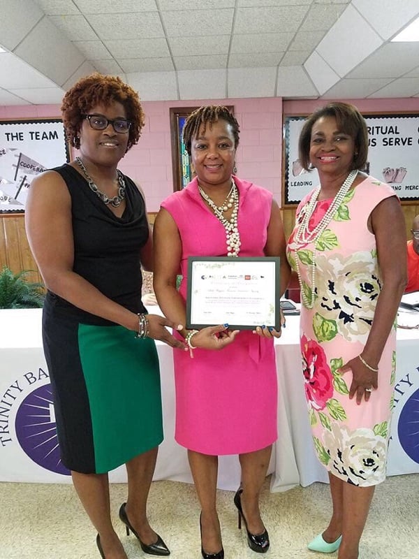 Photo of three woman posing with a certificate.