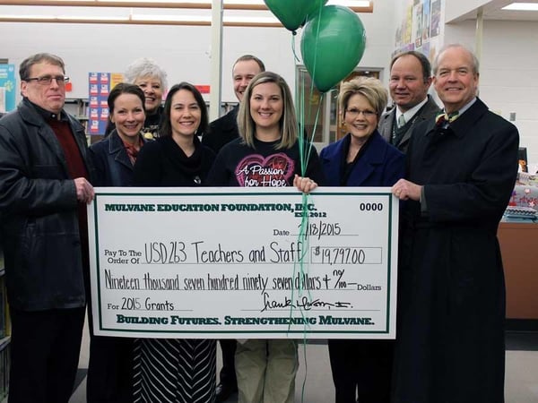 Group of people holding check