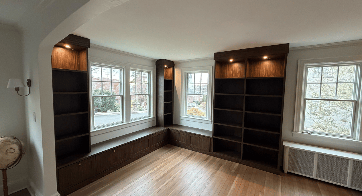 Dark Wood Home Library Dark wood built-in home library with window seats and storage underneath.
