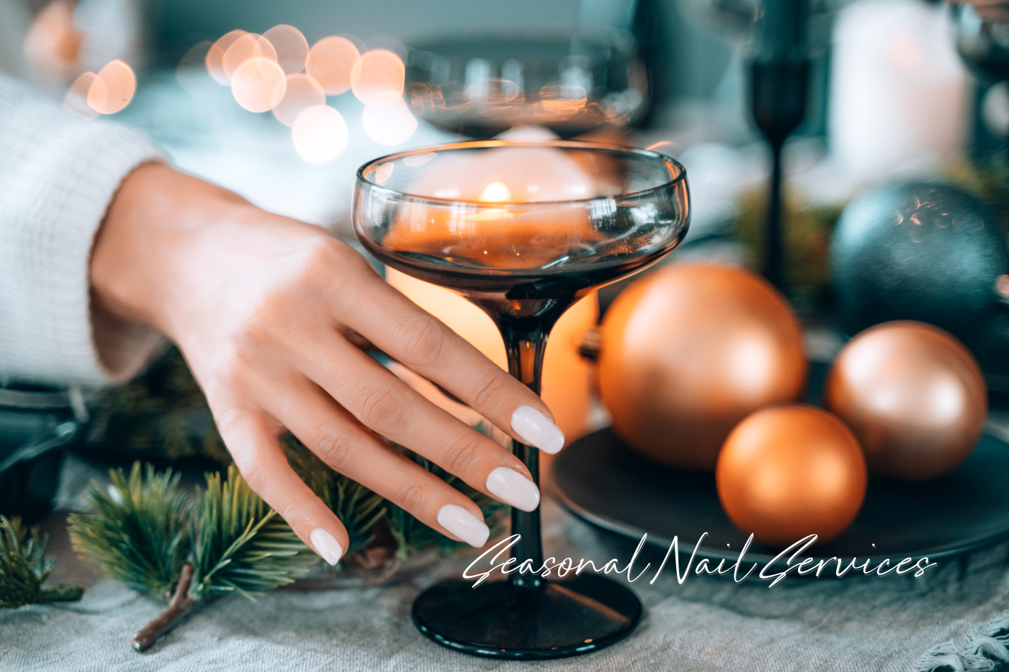 A woman showing off a wintery Farmhouse Fresh manicure, holding a glass of sparkling wine.