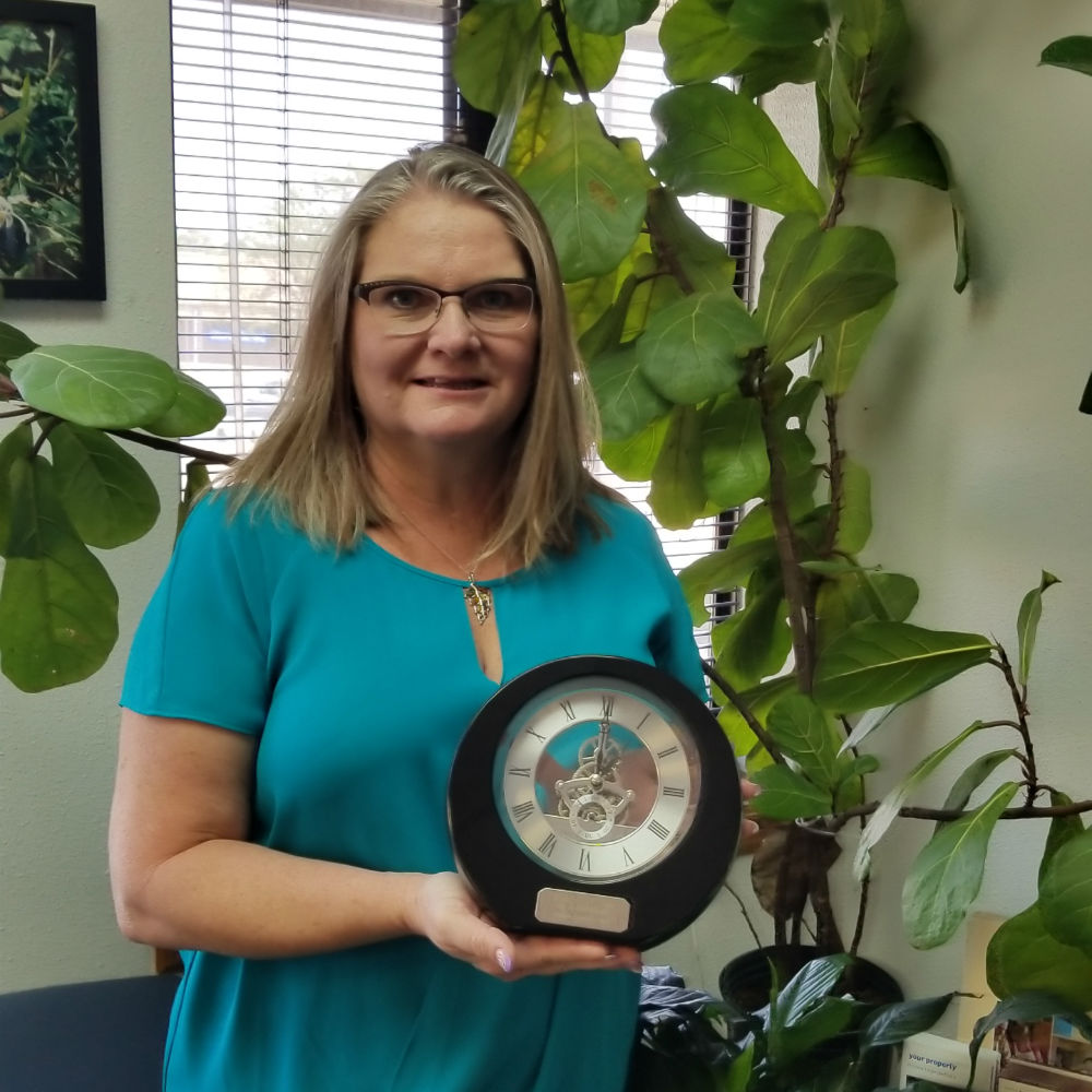 Samantha Ortega, Office Manager, with her 10th anniversary clock.