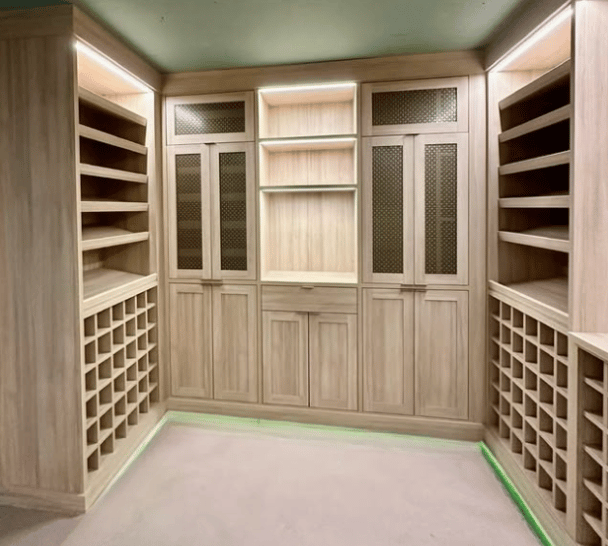 Custom Wine Room Light oak wine room with lighting, cubbies for wine bottles and gold mesh door inserts