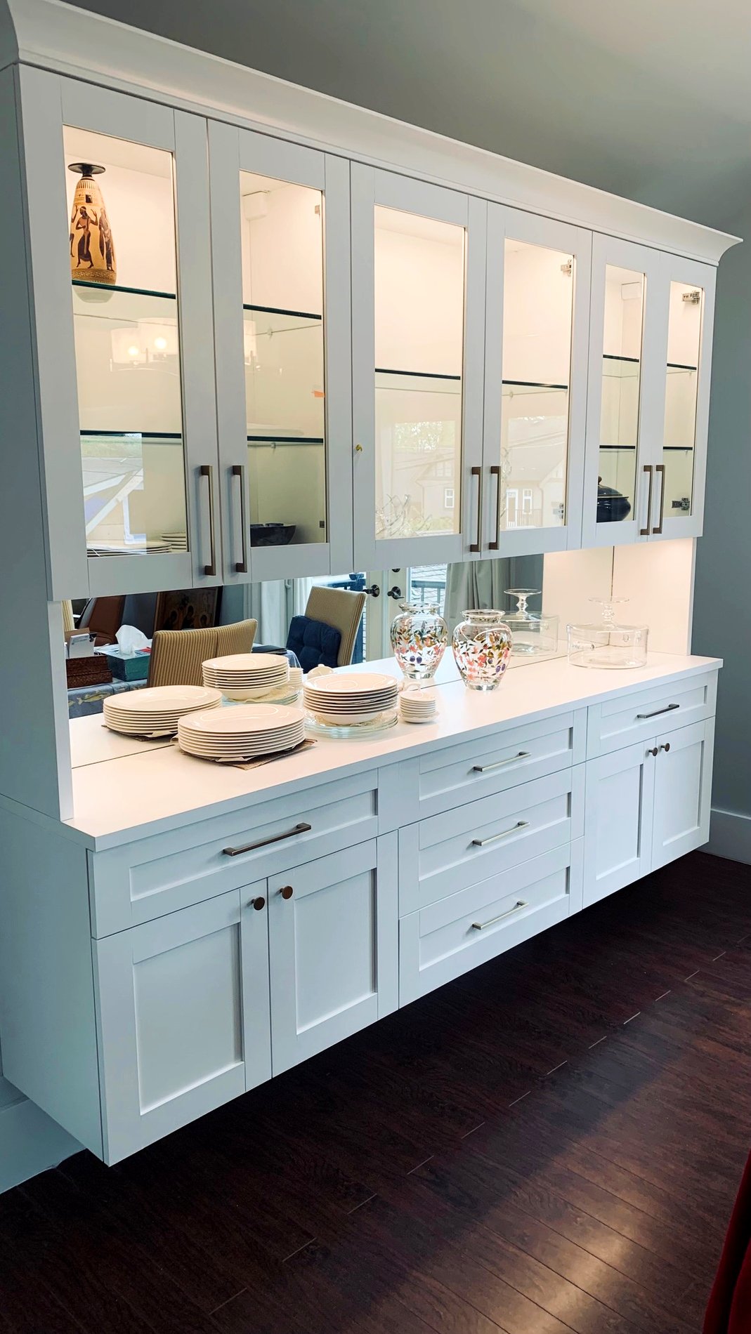 Floating china cabinet Floating dining room china cabinet with a mirror back panel and glass doors for display