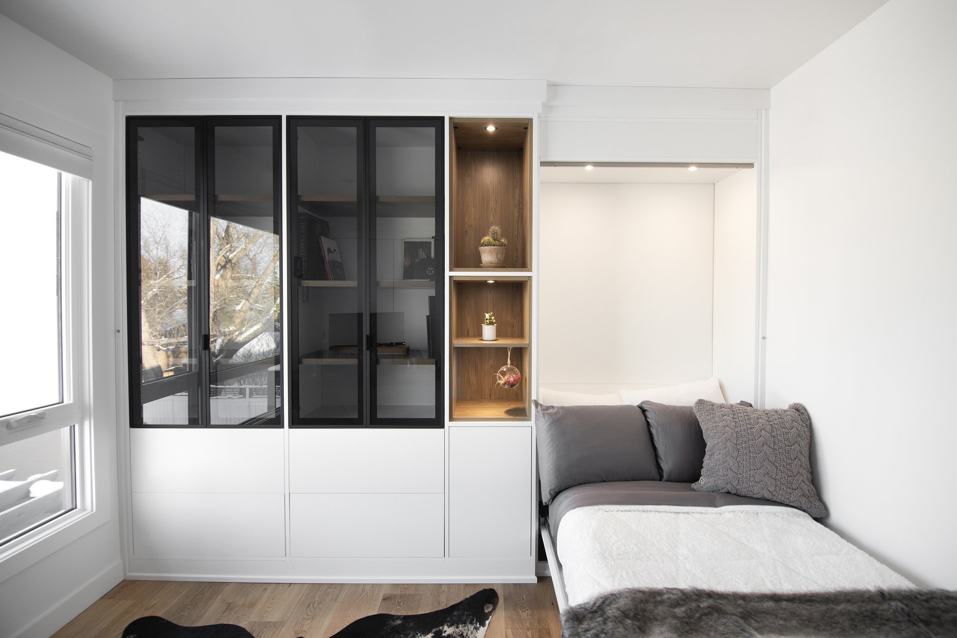 Contrasting and Modern Murphy Bed Modern wall bed design in white with contrasting black frame doors and glass inserts. Warm it up with a mid-tone wood grain finish.
