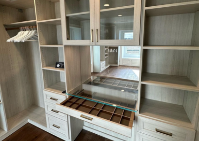 Luxe walk-in closet with glass cabinets and Everstyle drawer by California Closets Myrtle Beach, South Carolina.