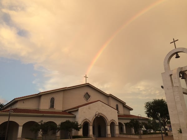 A church in the evening with a rainbow in the background