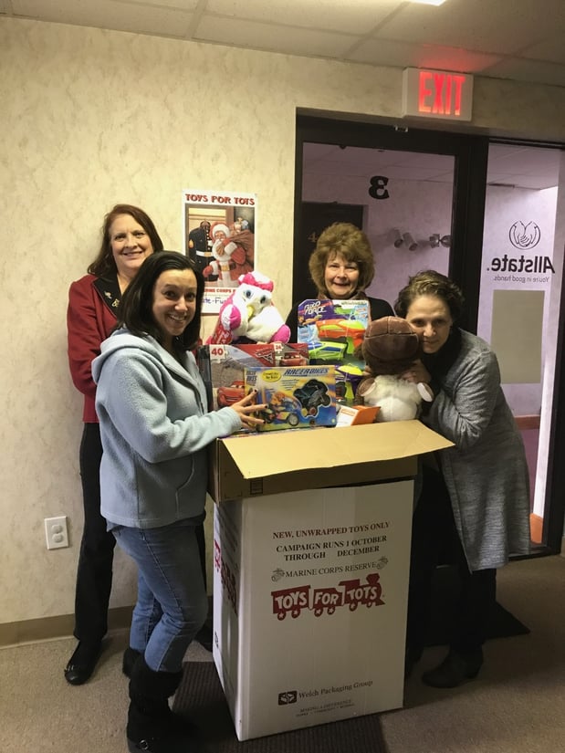 Our staff along with Pam from the North Providence Rotary Club with the many donations for Toys for Tots.