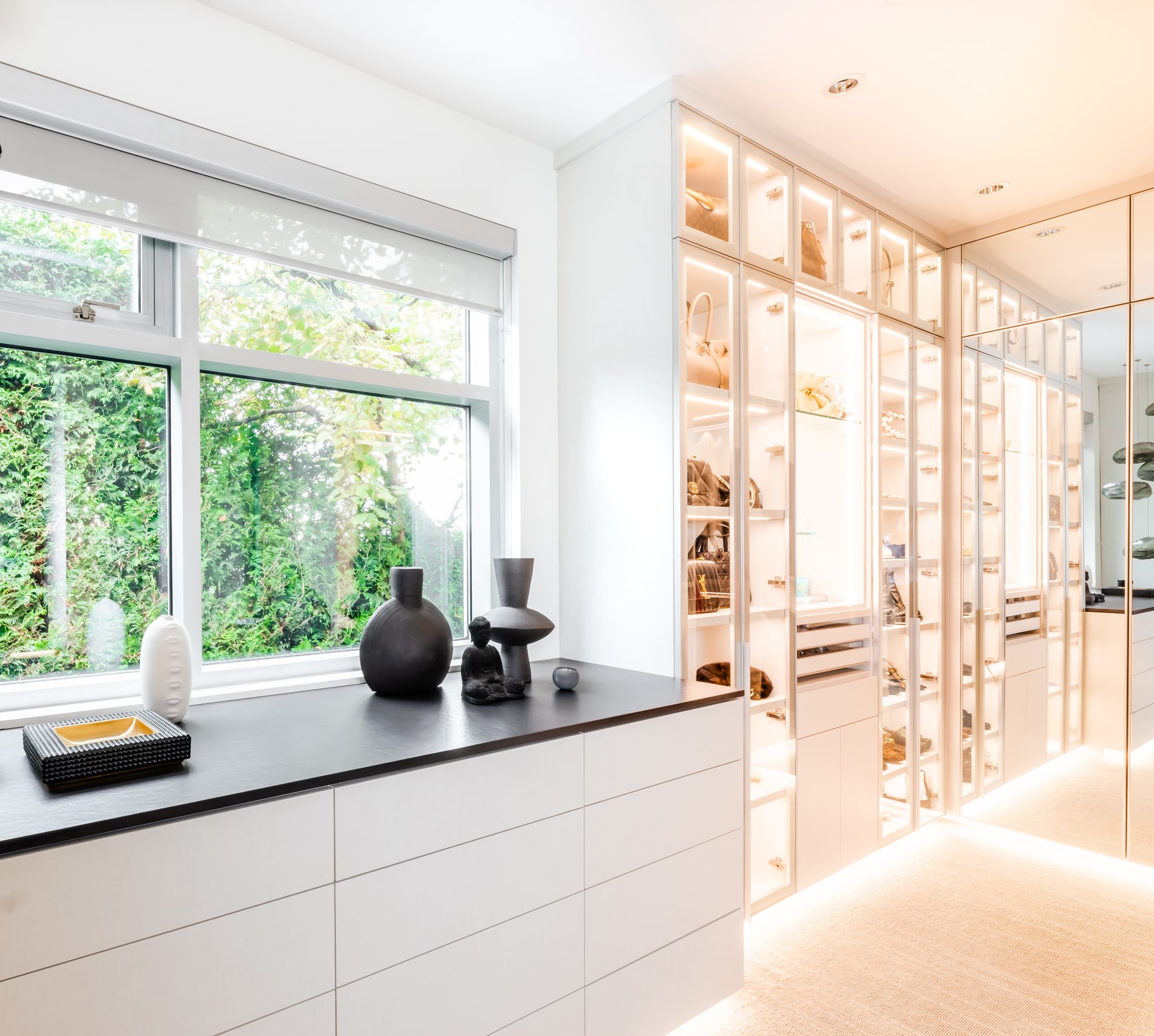 Spacious Walk-In Closet large walk in closet with counter space and built in lighting by California Closets Vancouver, British Columbia.
