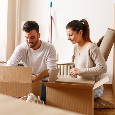 Couple packing up moving boxes at home