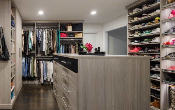 Gray Walk-in Closet Img 2 California Closets Westchester County NY Gray Walkin Closet Full Room Dressing Room with Double Hanging Dedicated Shoe Wall with Lighting and a Center Island with Black Leather Jewelry Drawers
