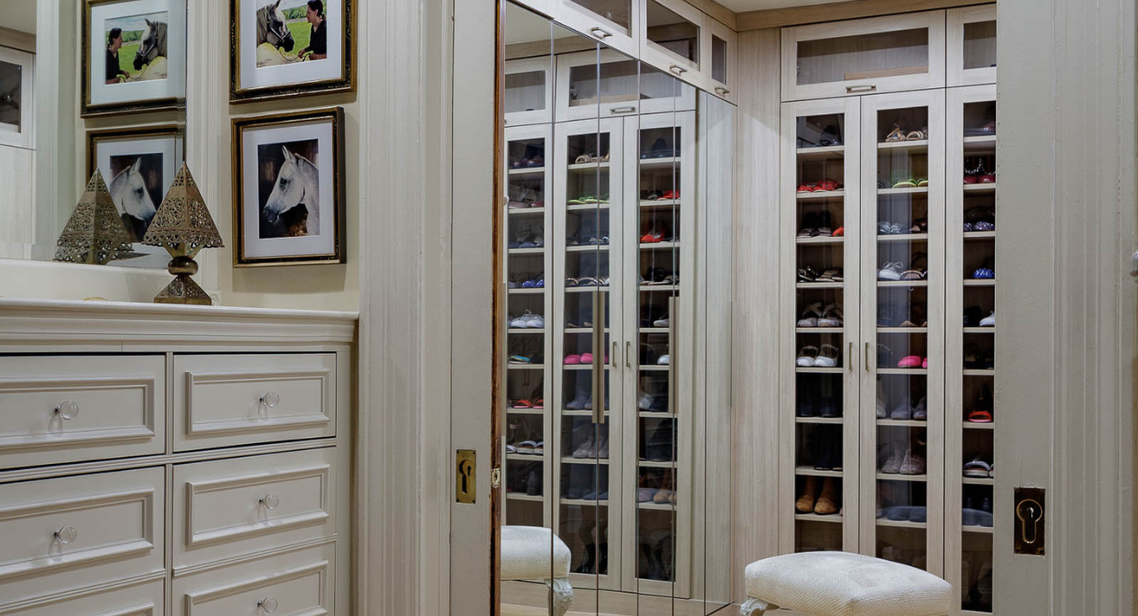 Sophisticated Walk-In Closet natural wood walk-in closet with mirrored doors, glass doors for floor to ceiling shoe storage to look like boutique closet Tribeca New York