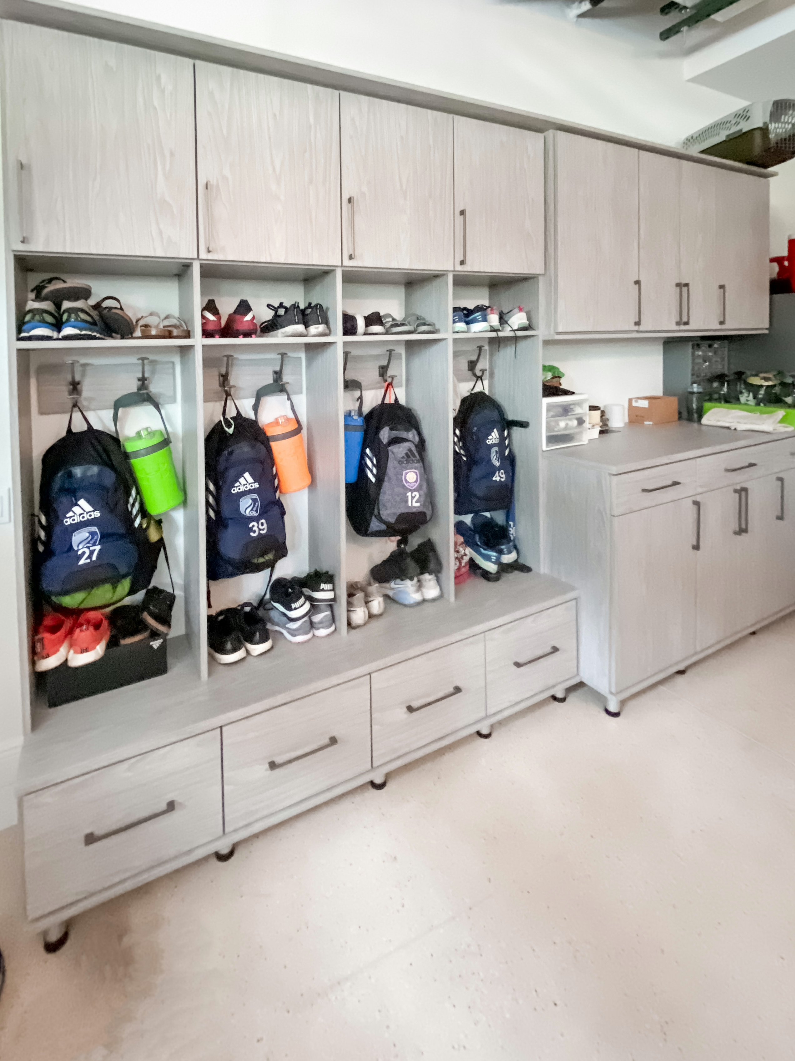 Custom Garage storage with Kids locker space Modern grey garage storage with custom storage and kids lockers by California Closets Sarasota, Florida.