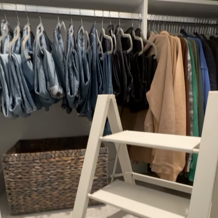Custom closet with hanging rods, shelving and a step ladder for extra reach.