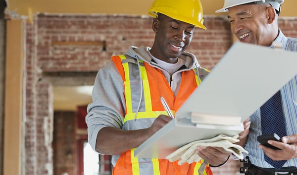 Construction workers reviewing contractual risk transfer plan