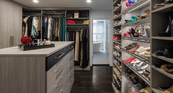 Img 9 - California Closets Westchester County NY Gray Walk-in Closet Full Room Dressing Room with Double Hanging Dedicated Shoe Wall with Lighting and a Center Island with Black Leather Jewelry Drawers