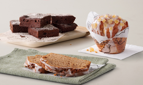 Freshly baked treats from Mugg & Bean On-The-Move, including a Citrus & Ginger Giant Muffin, Gingerbread Loaf Cake, and a chocolate brownie Sweet Square.