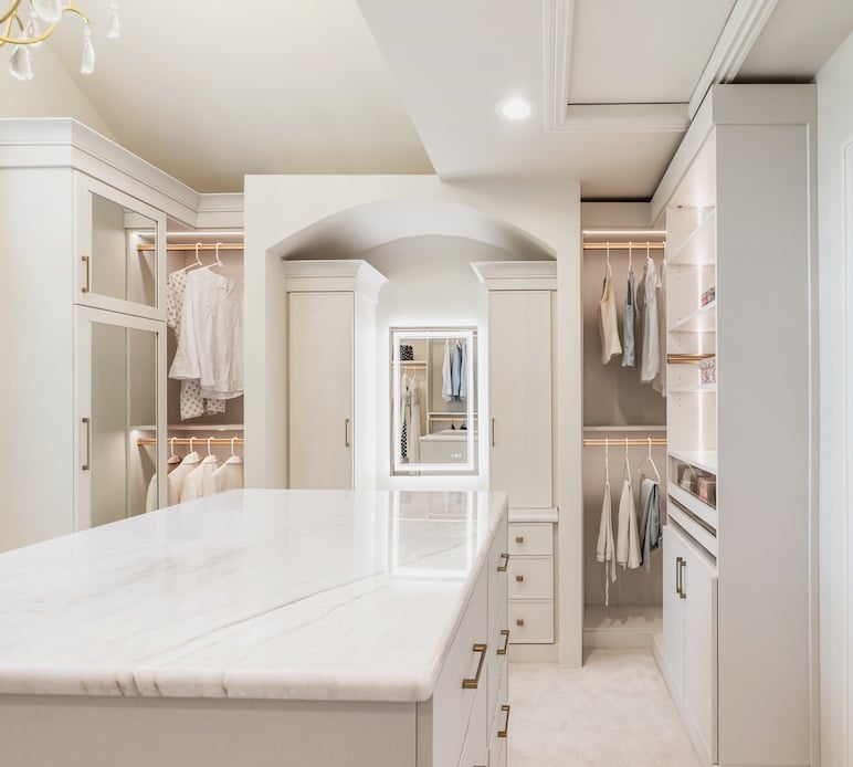 Luxury custom walk in closet with closet systems, closet cabinets, island drawers, vanity, and closet organization in Troy, Michigan by California Closets Greater Detroit