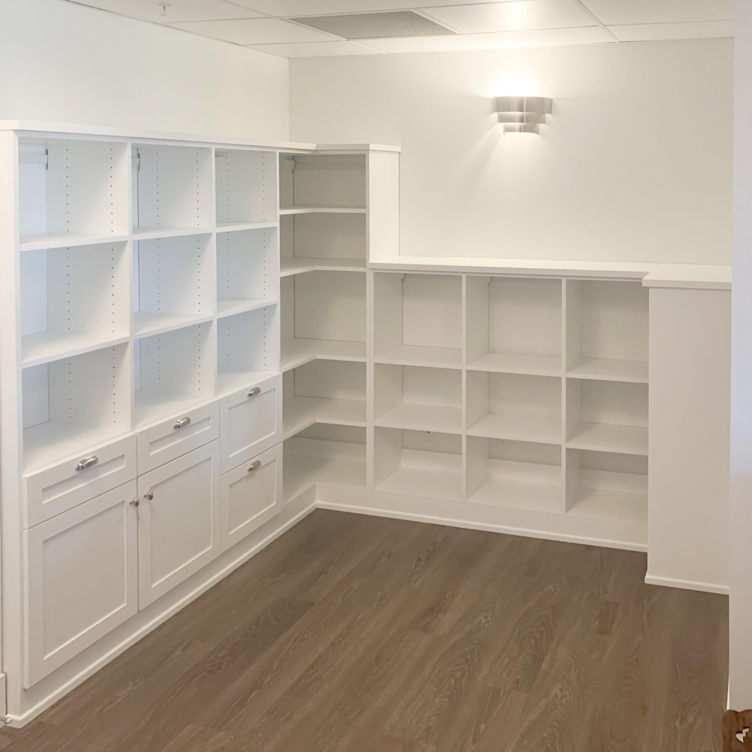 Corner library in white with mostly open shelving and a few closed cabinets.
