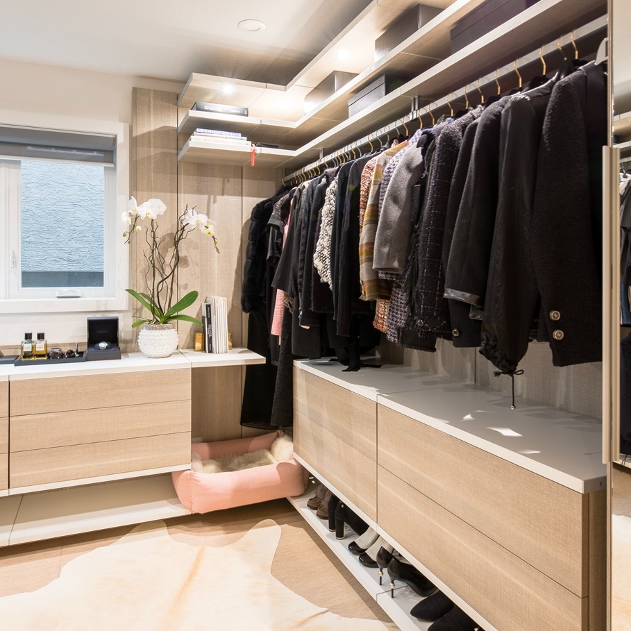 Modern walk in closet with floating shelves and drawers.
