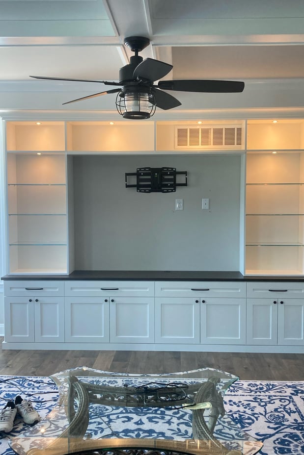 Custom Media Center with Accent Lighting, Glass Shelves, and Extra Storage