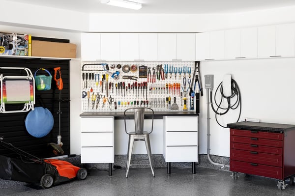 Garage workbench designed with drawers, contrasting countertop, and black slatwall.