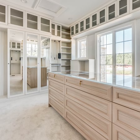 Luxury Walk In Closet with a window, Island and mirrored doors by California Closets Northern Michigan