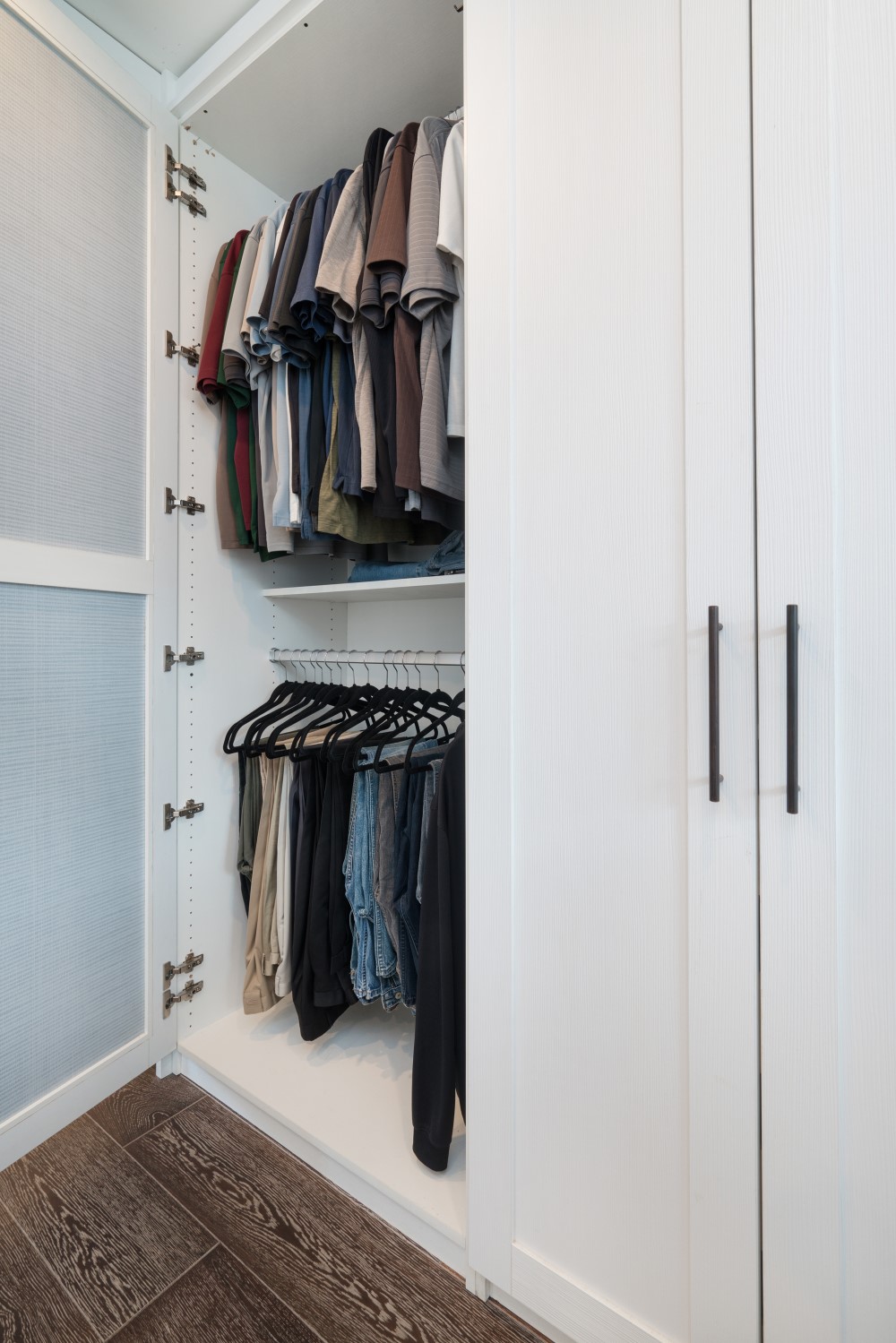 Custom wardrobe buildout with floor to ceiling storage by California Closets Hawaii in classic white finish.