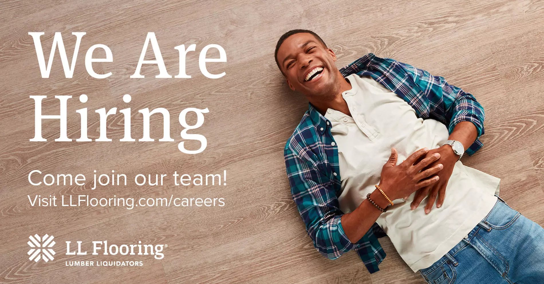 We are Hiring. Come join our team! Visit llflooring.com/careers. Man lying on hard surface floor.