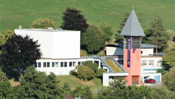 Die Evangelische Johanneskirche wurde 1964 in Hanglage erbaut. Kirche, Kirchturm, Gemeindehaus, Gemeindebüro und Pfarrhaus bilden eine baulich miteinander verbundene Einheit. Eine breite, überdachte Treppe mit mehreren Kommunikationsflächen bildet den Verkehrsweg. Alle Gebäude, inkl. des Kirchturms, verfügten ursprünglich über ein Flachdach. 1998 wurde der Kirchturm um einen hölzernen Glockenkäfig mit pyramidenförmiger Dachkonstruktion aufgestockt. Das ganze Ensemble ist schlicht gehalten. Beton ist das hervorstechende Baumaterial.