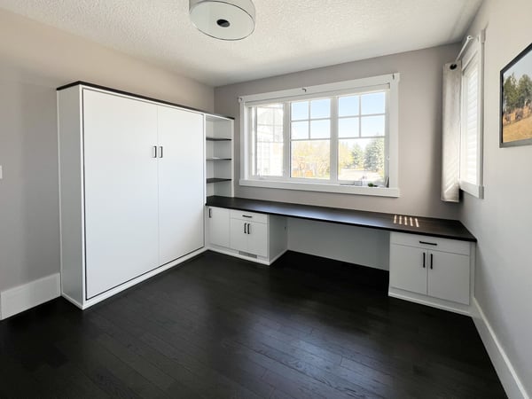 White and black home office with a wall bed.