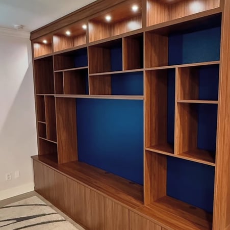 Custom media center in Sienna finish with Blue Wave backing and integrated lighting for a warm, modern entertainment solution.