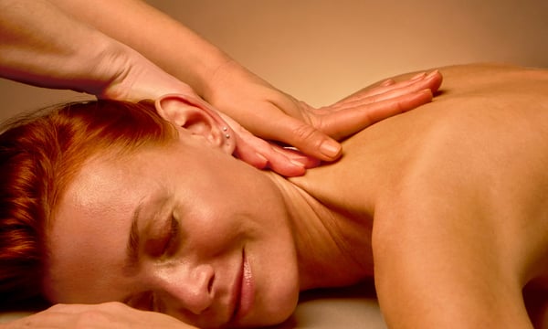 Woman enjoying a therapeutic back massage at Woodhouse Spa Castle Pines