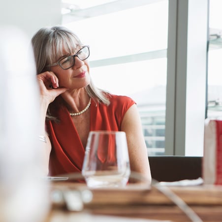 Older woman contemplating in an office.