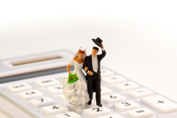 電卓の上にのる新郎新婦のミニチュア人形