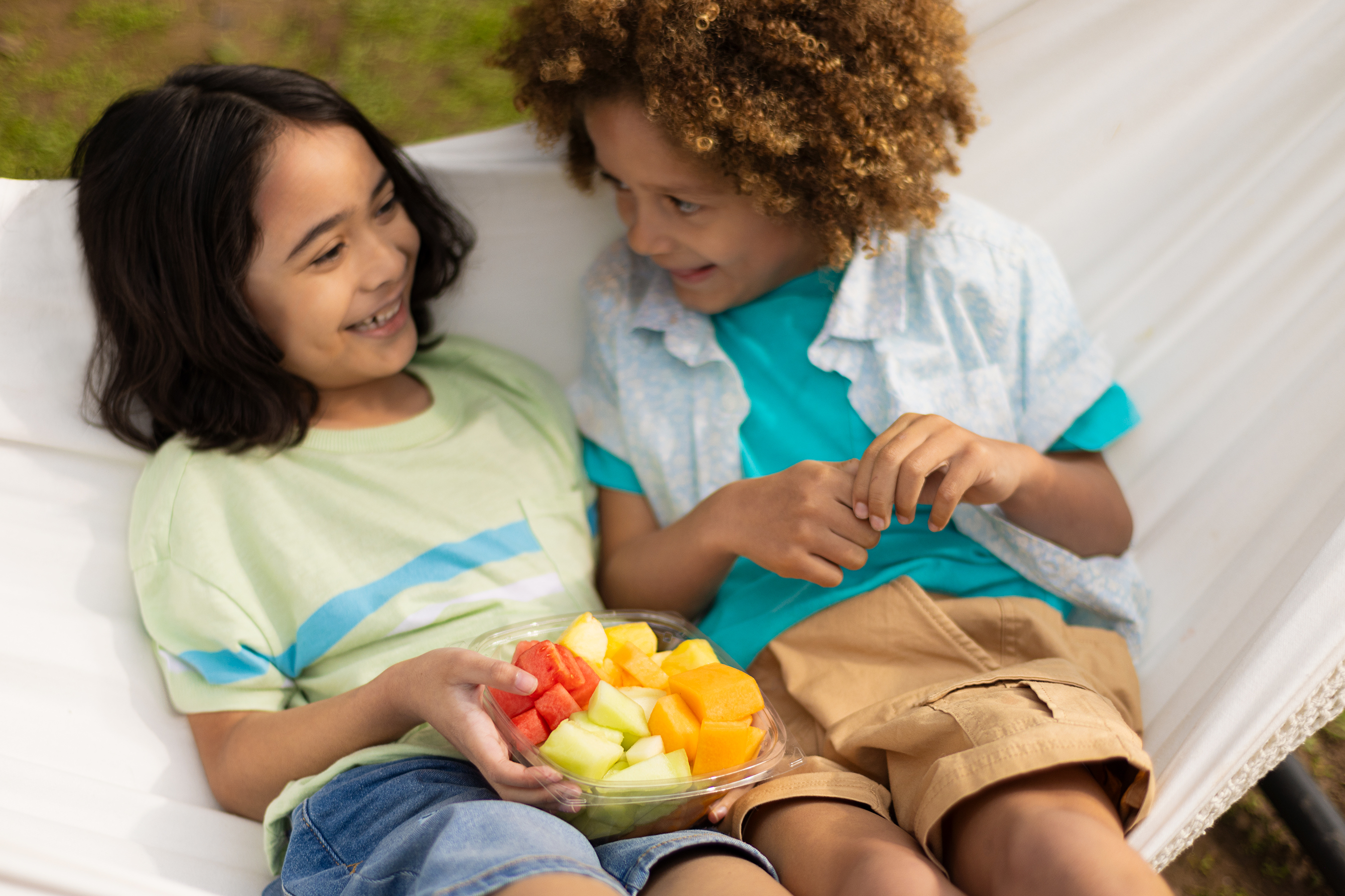 two kids eating fresh fruit