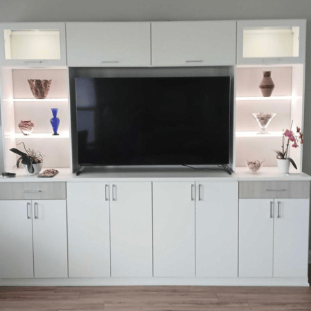 White cabinets and lit shelving for a living room or bedroom wall.