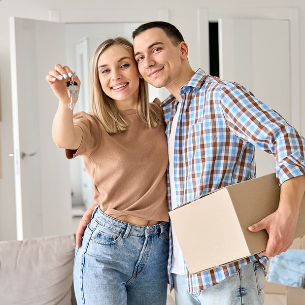 A woman holding a key next to a man holding a cardboard box.