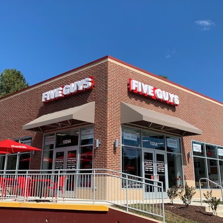 Exterior photograph of the entrance to the Five Guys restaurant at 1024 Seneca Road in Great Falls, Virginia.